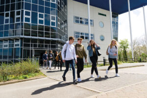 Students walking out of a college building at the end of their lessons.