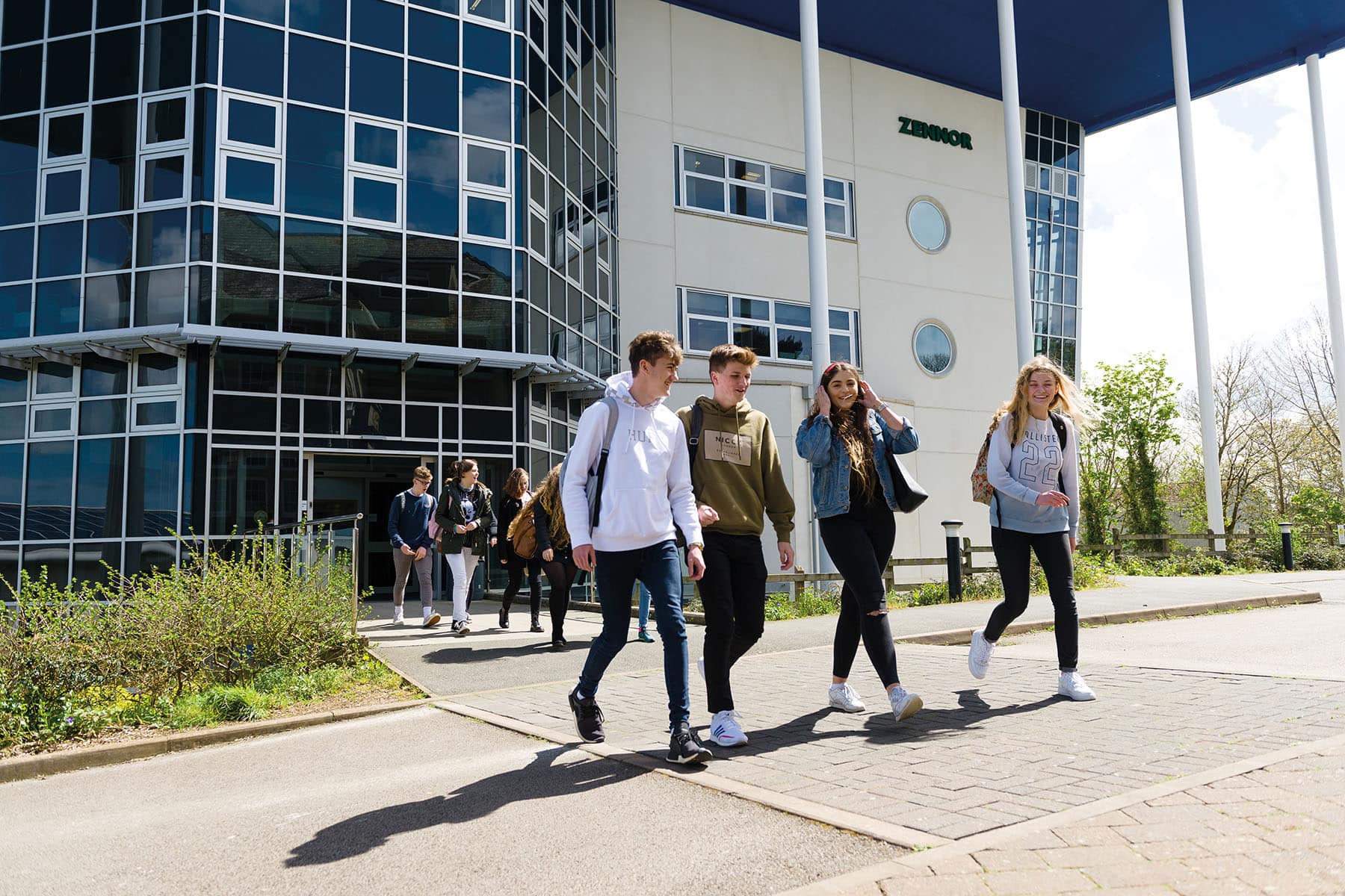Students walking out of a college building at the end of their lessons.