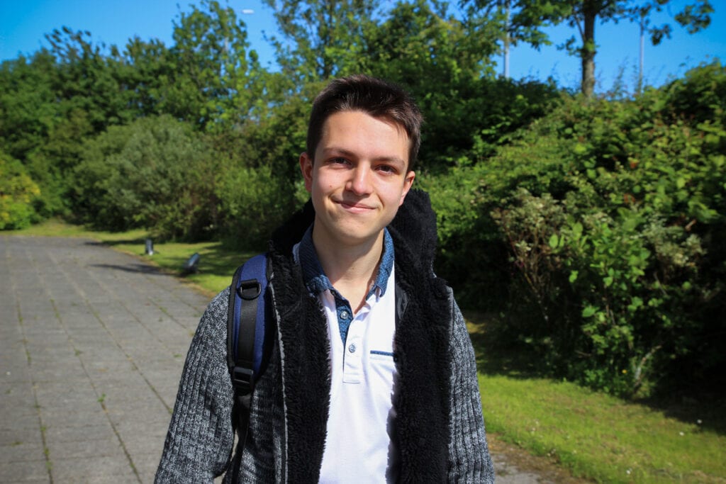 Jacob outside in front of greenery