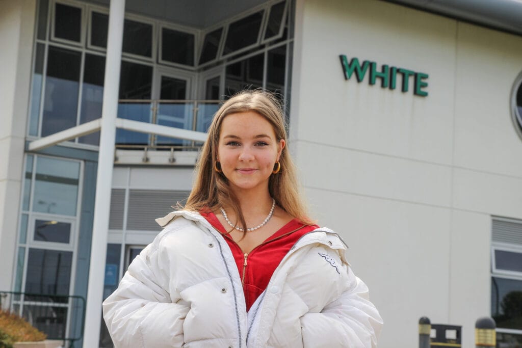 Close up of Una in front of the White building