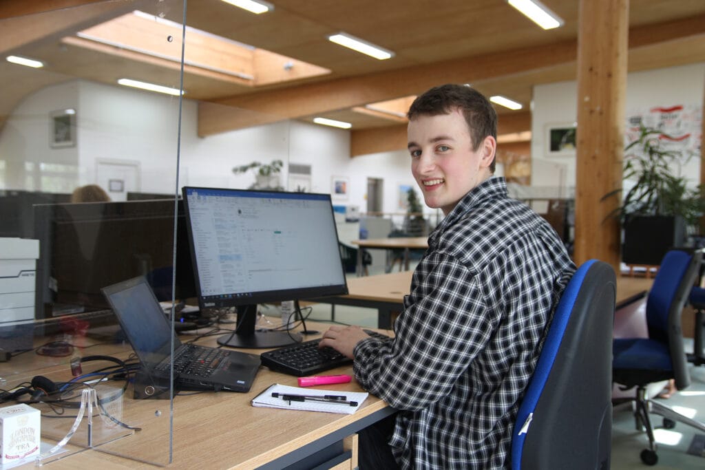 Tom working at his desk in an office