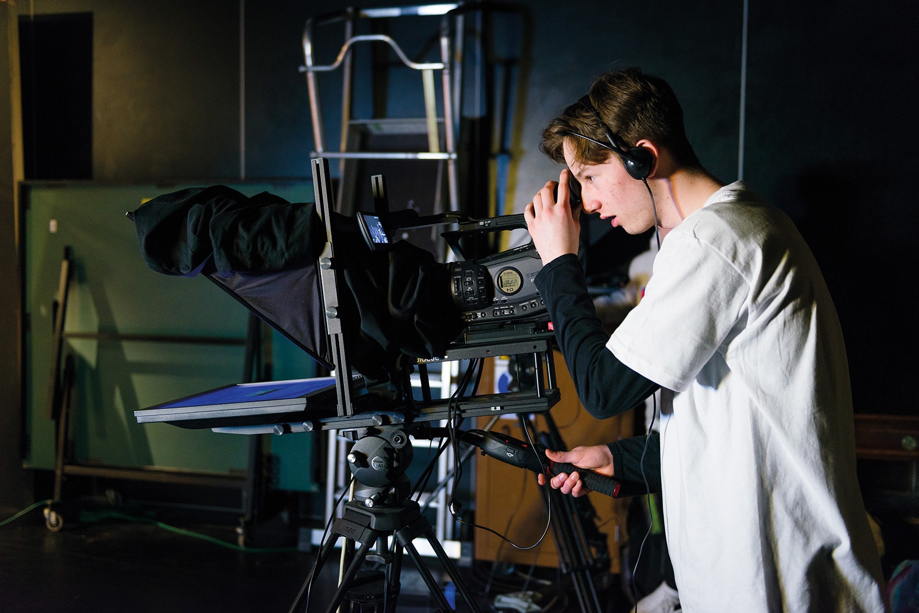 A media and photography student uses a professional camera in a media studio.