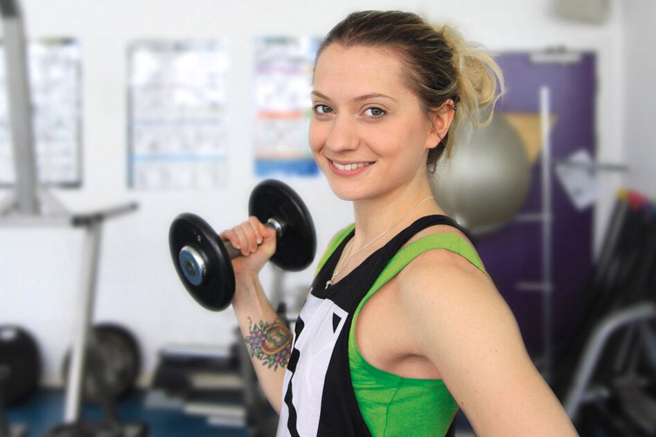 An adult learner exercising in a College gym