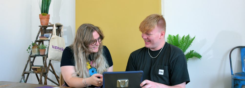 Miles sat with his manager looking at a tablet