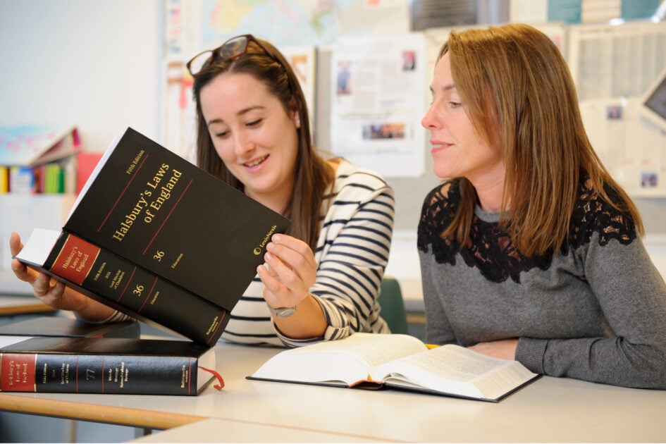 A business and law student looks through a book named Halsbury's Laws of England