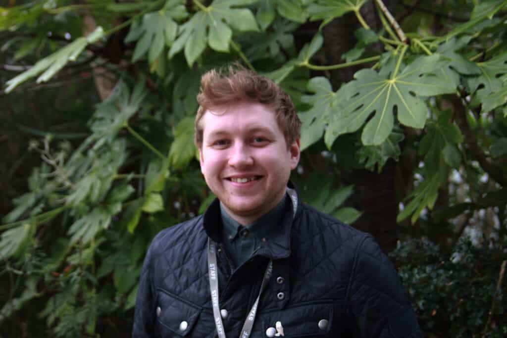 Luke outside in front of foliage