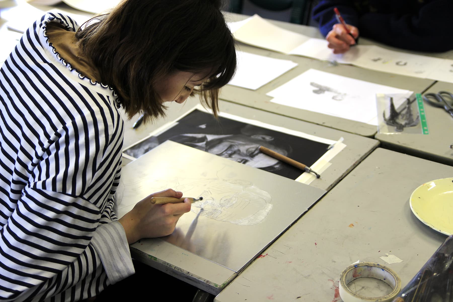 A photo of a student working on a piece of artwork.