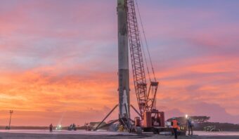 A stock image of a rocket being supported by a crane