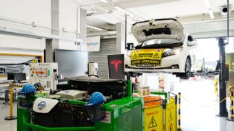 An electric car is being serviced in the automotive bay.