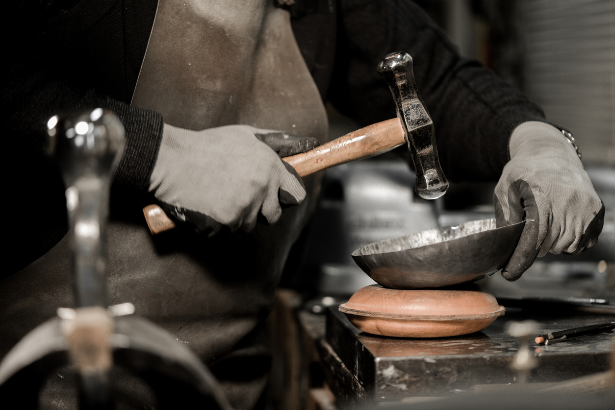 Master goldsmith working with silver-Shaping of the object by hammering
