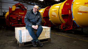 Duncan Wilson sitting on a pallet in the Teagle workshop.