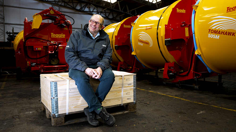 Duncan Wilson sitting on a pallet in the Teagle workshop.