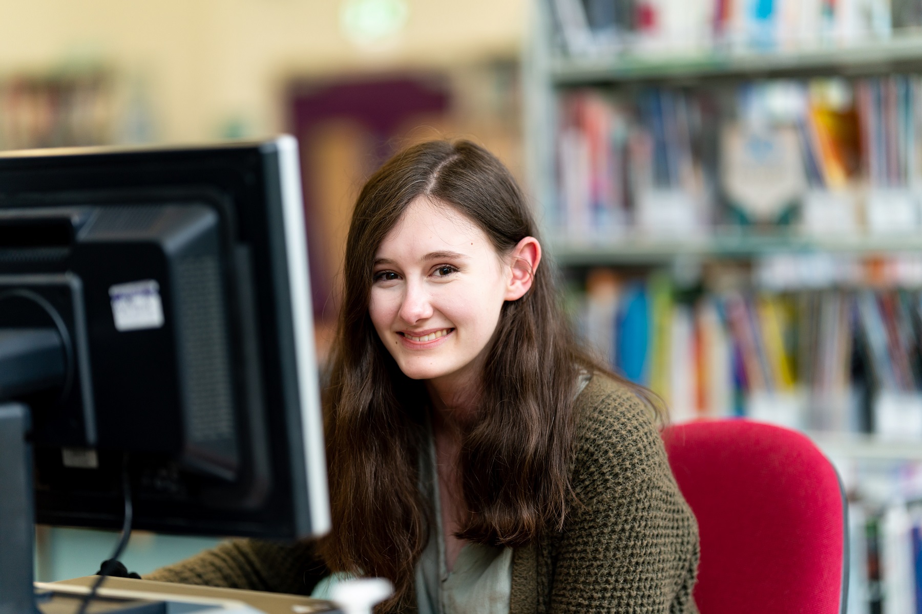 General FE PC 0010 A student smiles at the camera as she sits in front of a computer sat in one of the college's study centres.