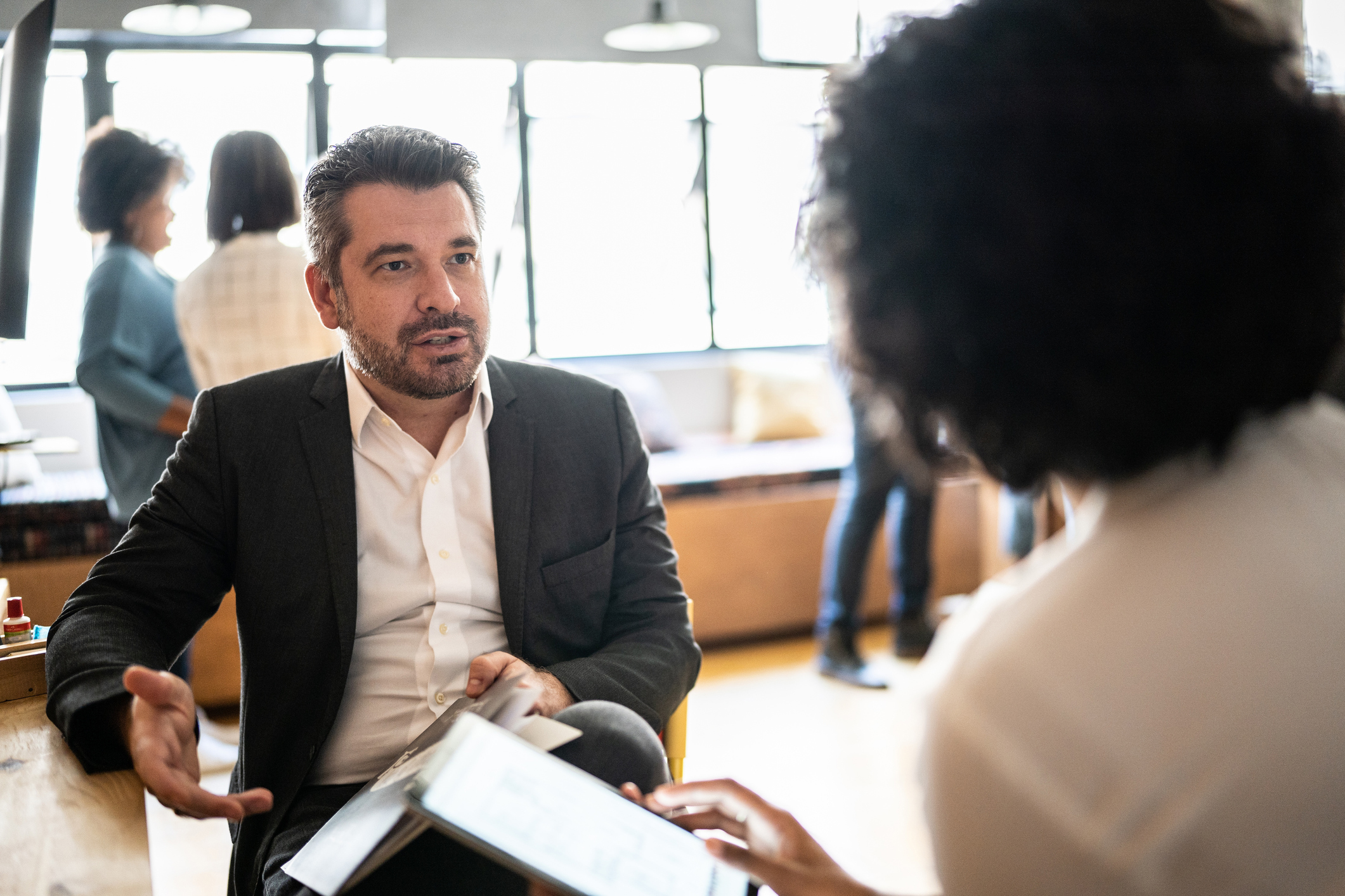 Mature man talking with a colleague at work