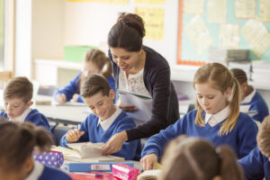 Female Teacher With Her Pupils In Classroom