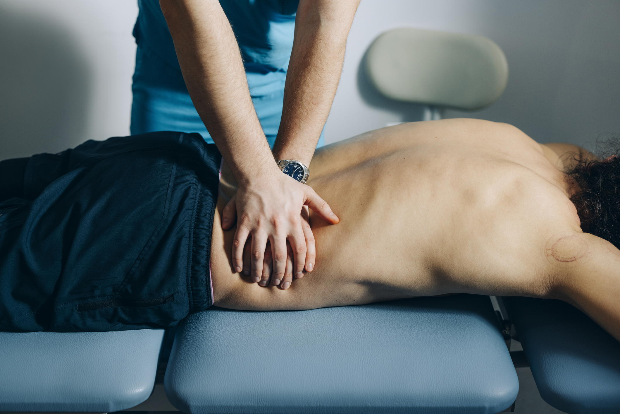 Unrecognizable young man lying on stomach having back massage