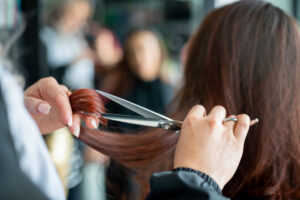 Close up of unrecognizable hairdresser cutting a female customer's hair.