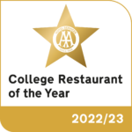 An award logo. The text reads 'College Restaurant of the Year 2022/23'. A gold star above the text has the words 'Hotel Services, since 1908' inside it.