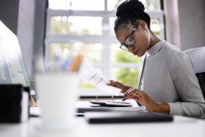 Accountant Or Auditor working on her desk in an office.