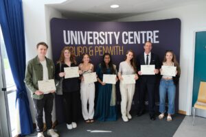 students holding certificates at an awards evening at the university centre.