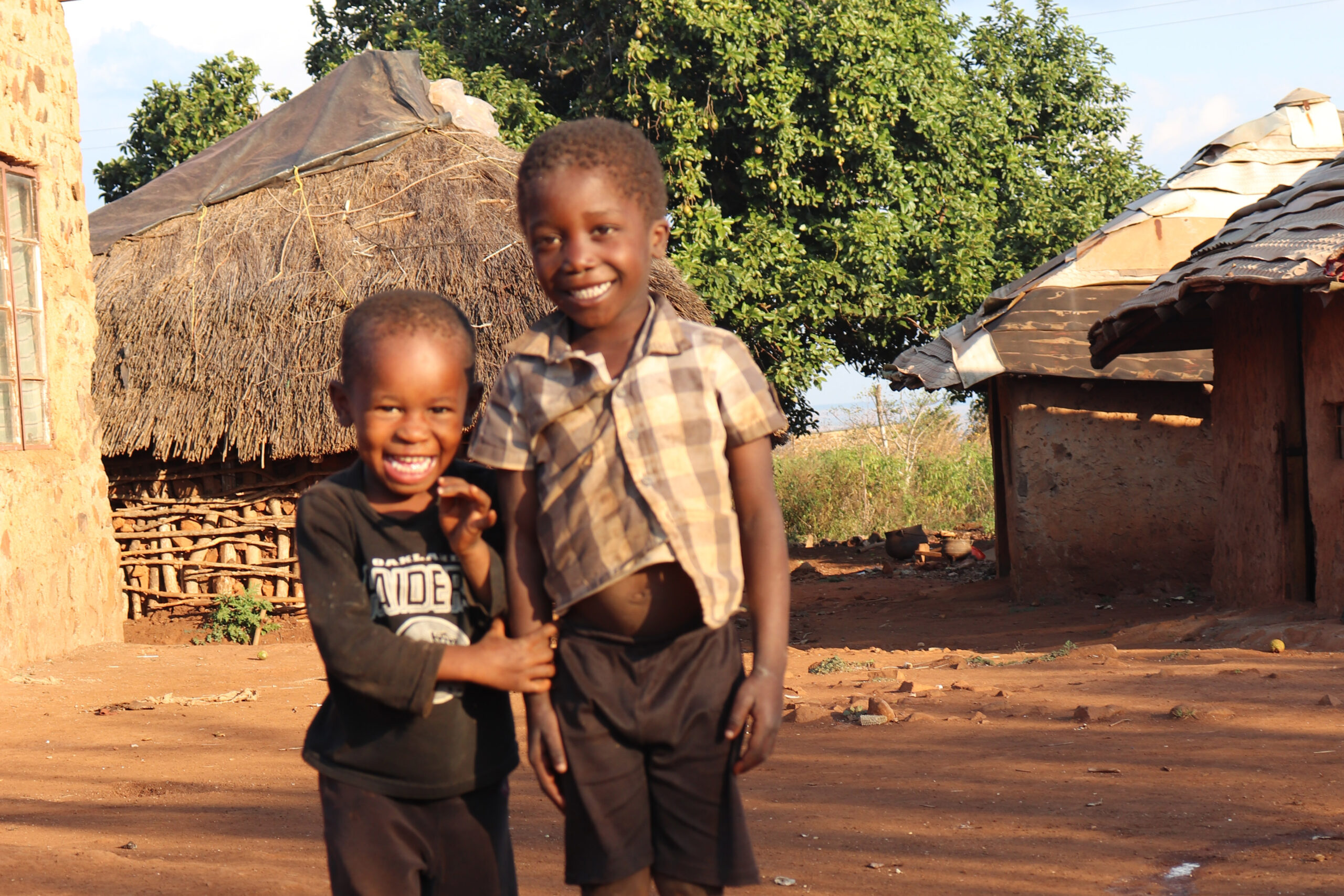 Two young Eswatini boys smile and laugh as they look at the camera