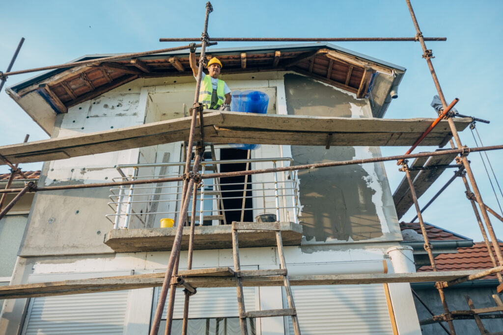 Construction Worker On Facade Scaffolding