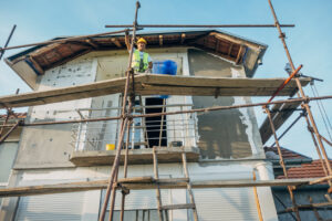 Construction Worker On Facade Scaffolding
