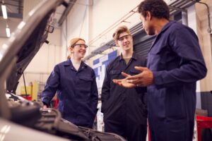 Male Tutor With Students Looking At Car Engine On a Course At College