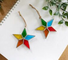 Two stained glass hanging decorations in the shape of stars.