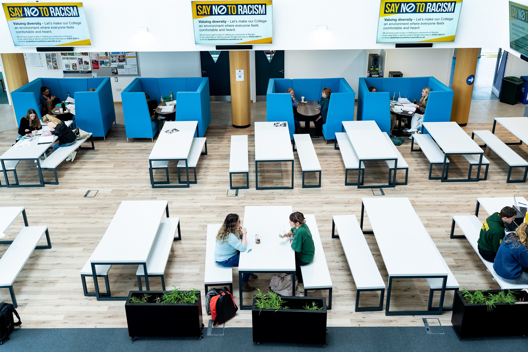 An aerial view of the Fal building canteen where students are enjoying drinks, studying and chatting with friends.