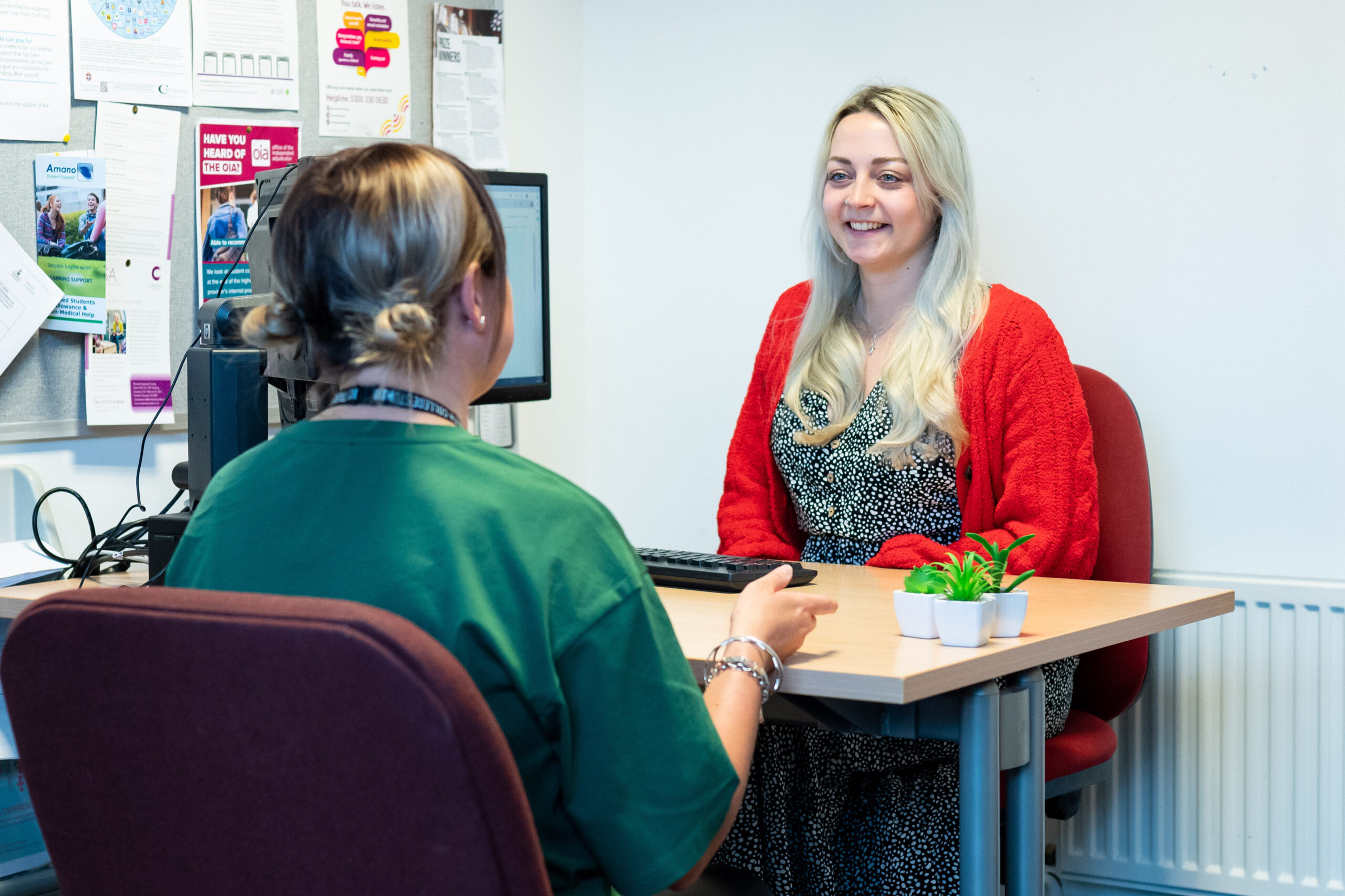 An adult student sits in an office at the University Centre Truro and Penwith with Senior Student Support Adviser Kelli. They are both smiling and chatting.