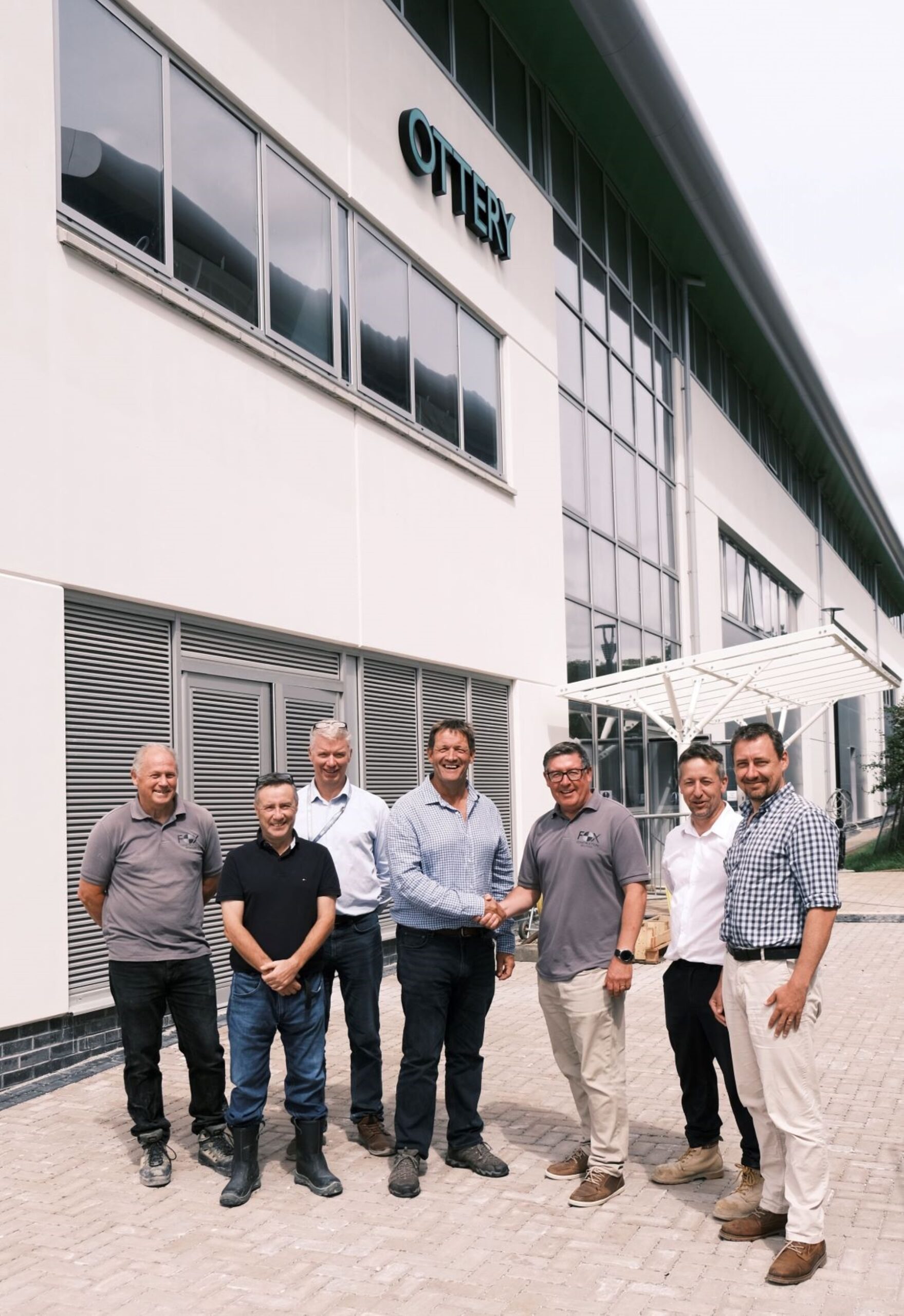 College Principal Martin Tucker shakes hands with Fox Construction's Kevin Bate at the key handover infront of the new STEM and Health Skills Centre in Bodmin as fellow members of team look on.