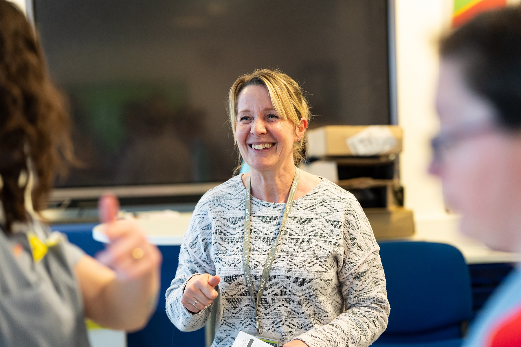 A tutor smiles happily at an unrecognisable person.