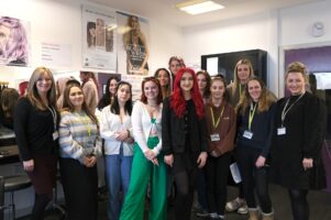 A group of hair and beauty students and teachers pose for a group shot with Olivia Hack, Tv & Fashion Hair & Make-Up artist during her visit to College.