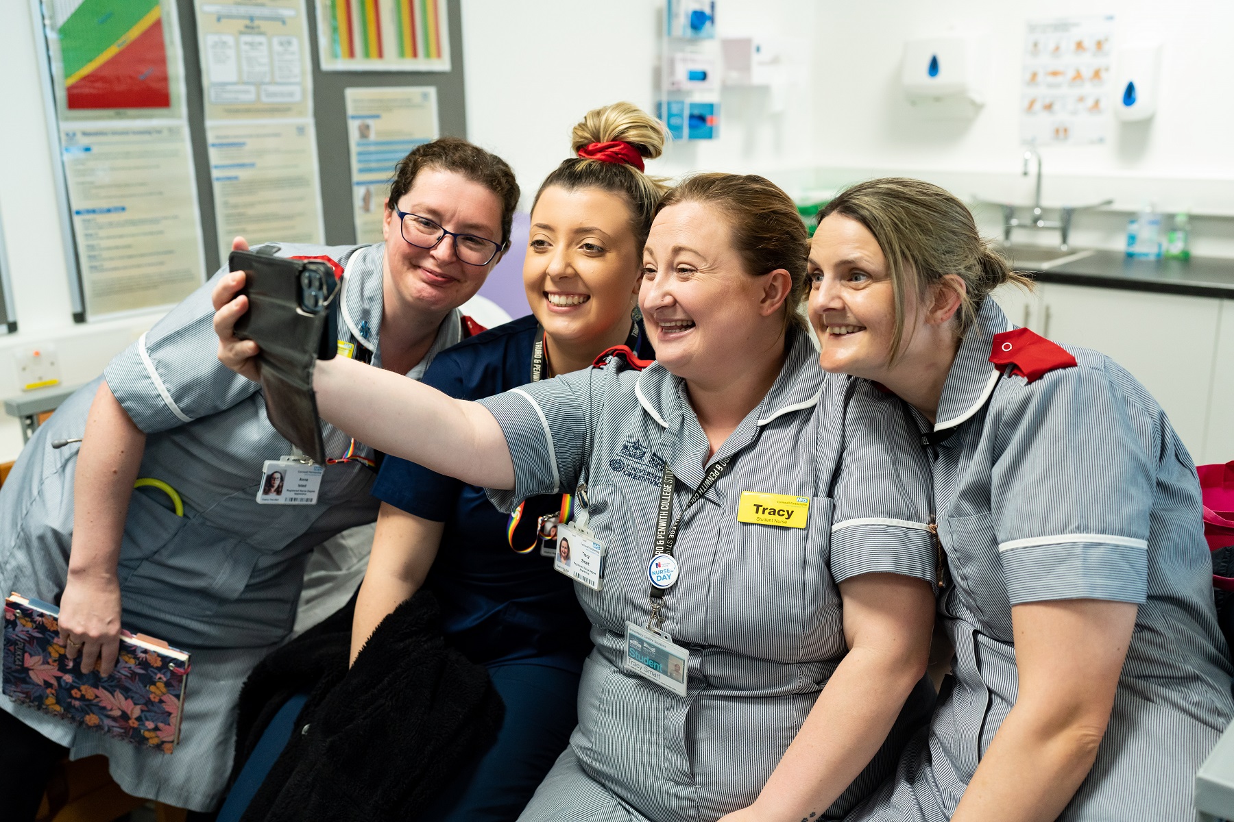 A group of nursing students take a selfie in their uniforms within a classroom at the University Centre Truro and Penwith.