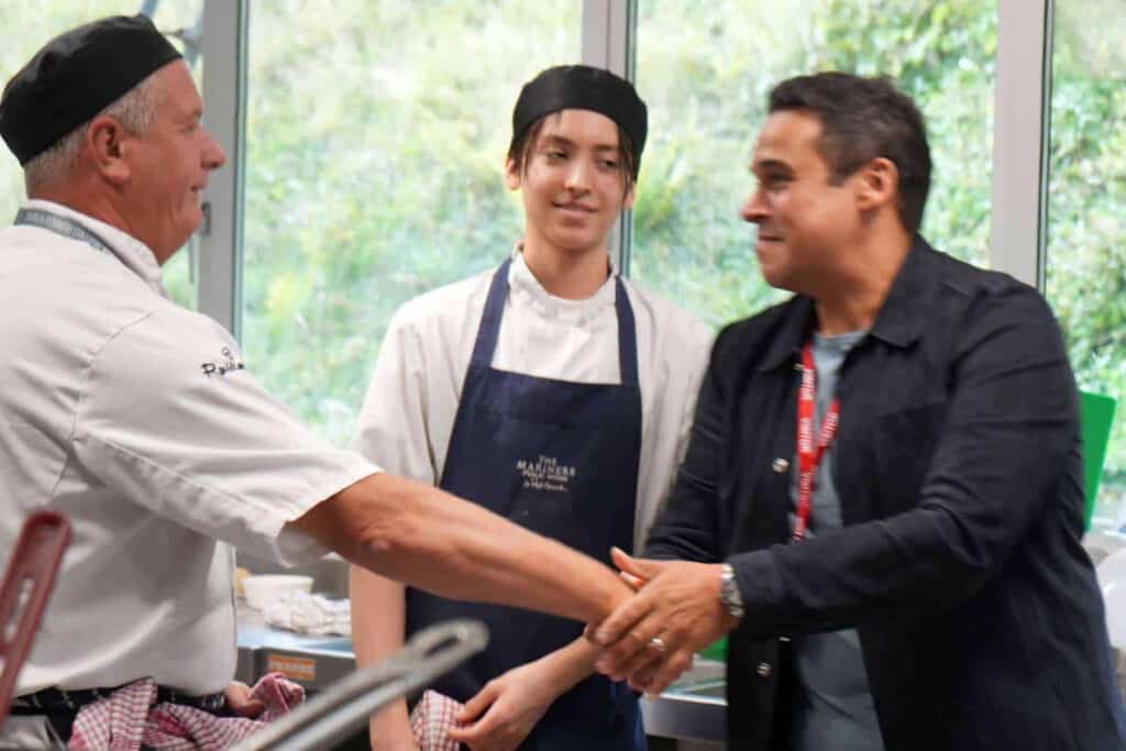 Paul Ainsworth shakes hands with professional cookery lecturer Andy