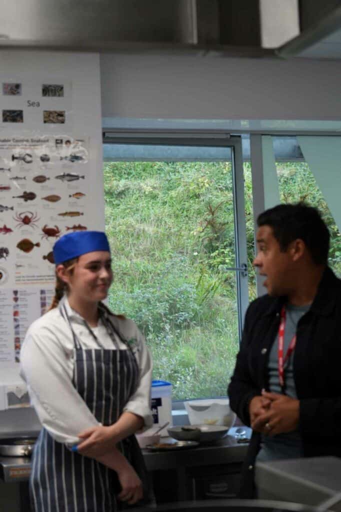 Paul Ainsworth chats with a professional cookery student in the college kitchen.