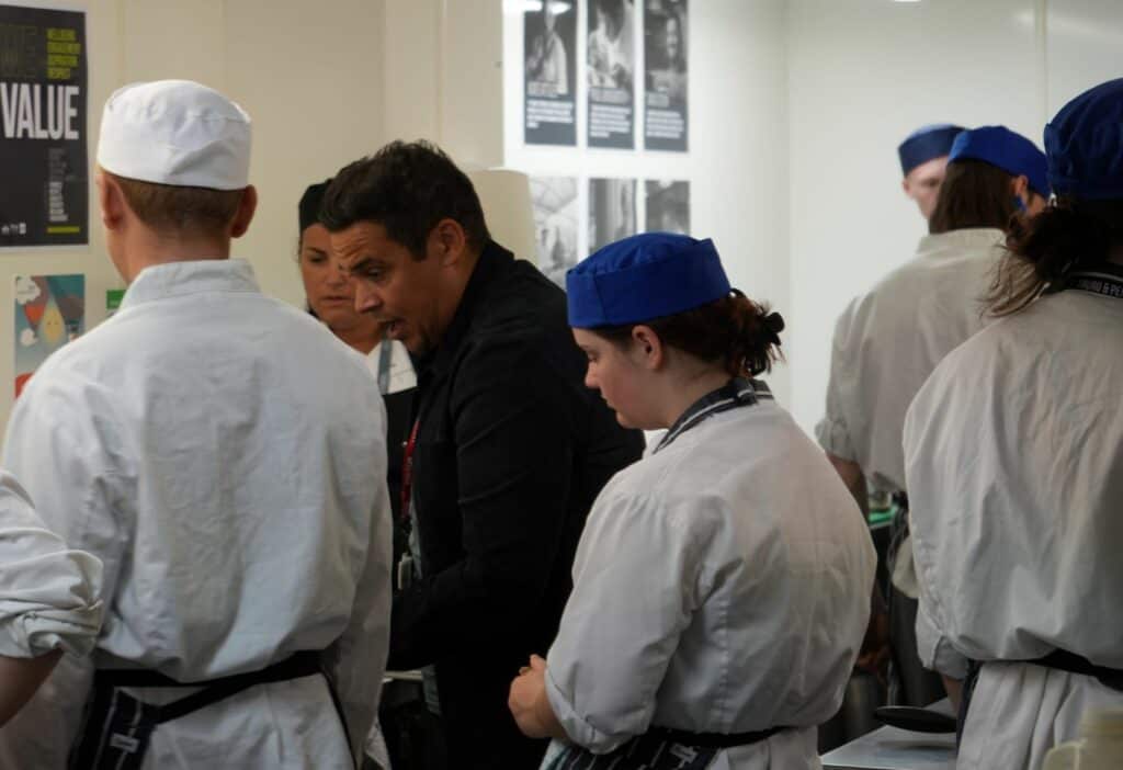 Paul Ainsworth shares tips with cookery students in the kitchen.