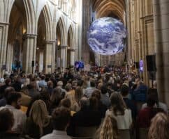 A shot of the Gaia globe artwork that was on display at Truro Cathedral during the University Centre's 2023 Graduation ceremony as guests watch on.