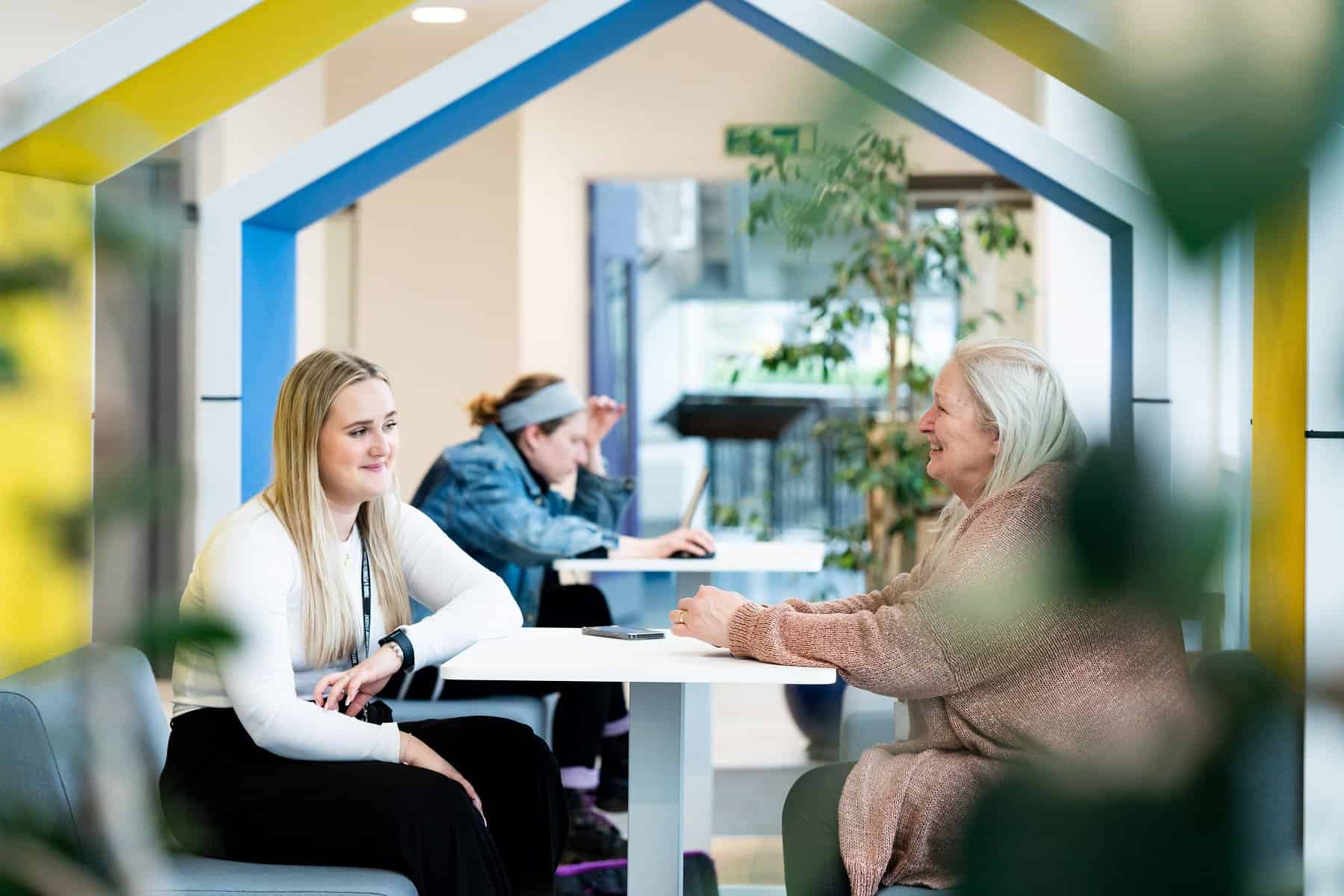 Two students sitting and chatting at the University Centre Truro & Penwith