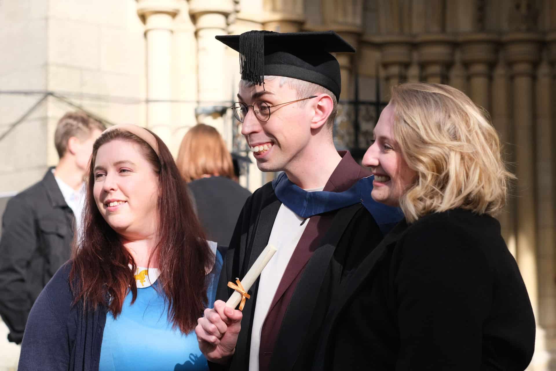 The University Centre Truro & Penwith Graduation 2023. An image of a graduate outside the cathedral with two guests.