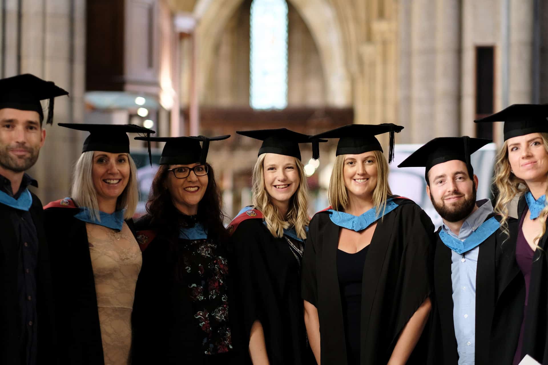 Graduates 31 The University Centre Truro & Penwith Graduation 2023. A group of graduates in cap and gowns smiling at the camera.