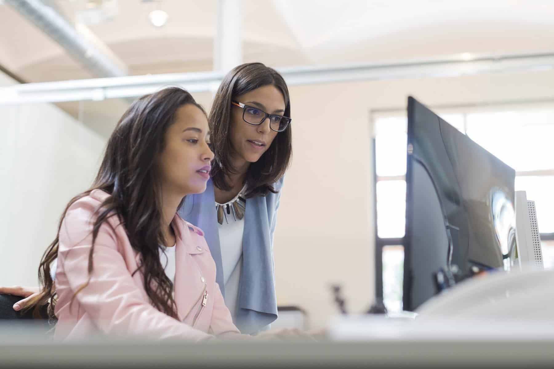 Business woman working together and sharing a computer.