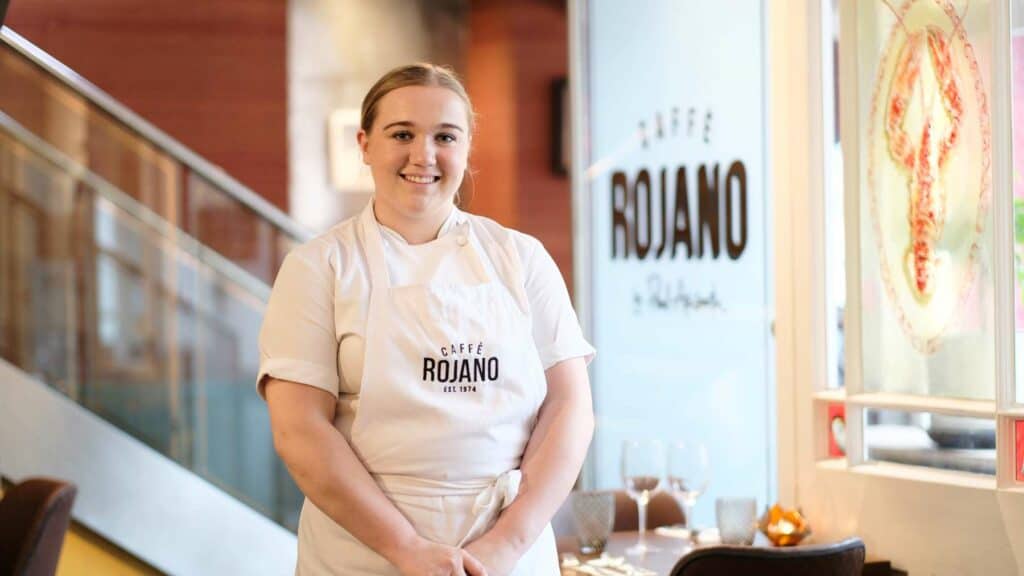 Isabelle is photographed in her apron in Cafe Rojano