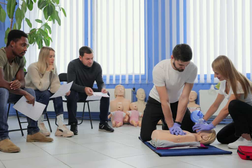 Male instructor teaching first Aid Cpr technique to his students