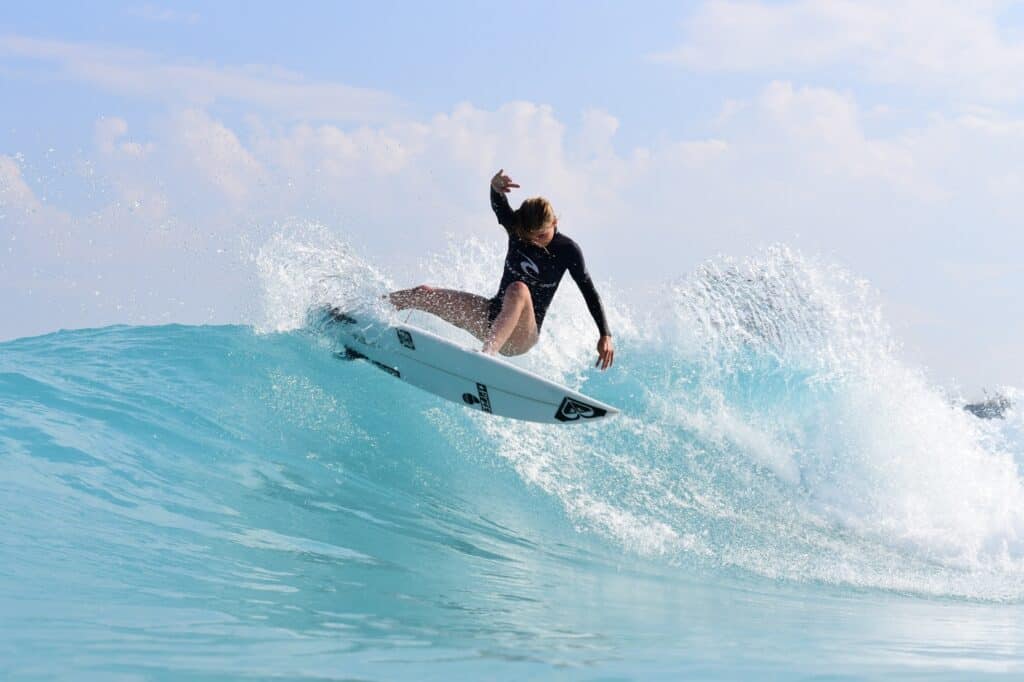Surfer rides of the top of a wave