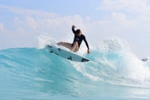 Surfer rides of the top of a wave