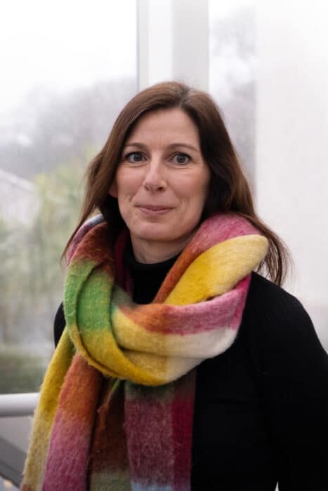 An image of Jodie Stafford, Department Team Leader for Personal and Professional Development at Truro and Penwith College. She is wearing a brightly coloured scarf against a dark top and smiling at the camera.