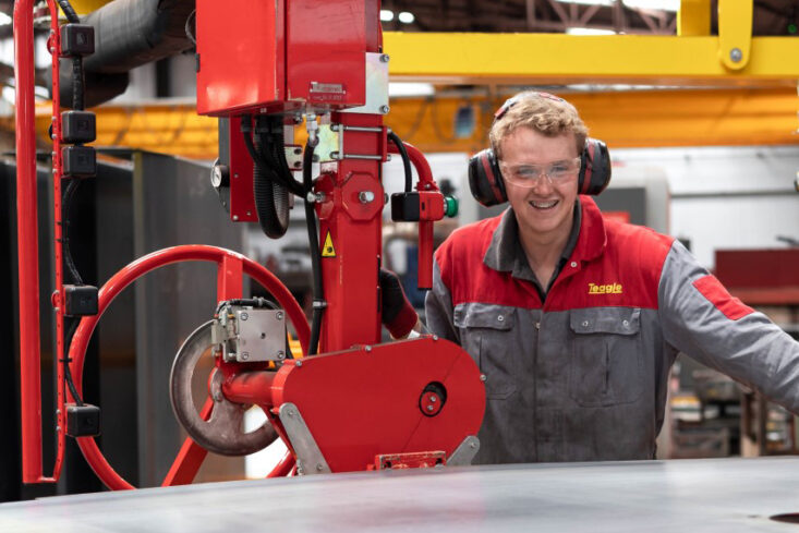 Jack Level 3 Technical Support Technician Apprenticeship at Truro and Penwith College. Jack wears overalls and protective wear, working with machinery at his workplace, Teagle.