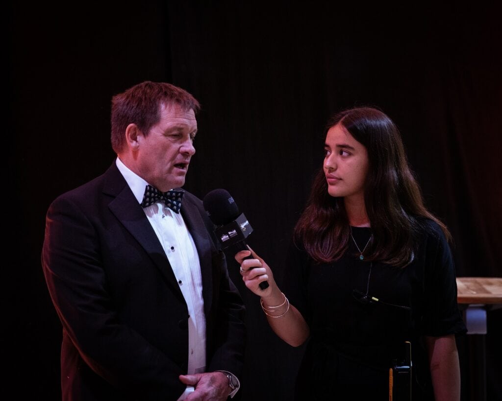 College Principal Martin Tucker was interviewed after the event, the interviewer is holding a Cornwall Apprenticeship Awards and College branded microphone towards Martin has he answers her questions.